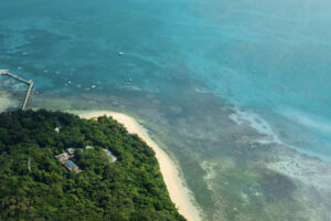 Luftaufnahme von Green Island mit Regenwald, Sandstrand und Korallenriff