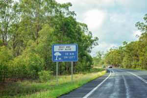 Hinweisschild „Rest and Stay Alive“ an einer australischen Landstraße