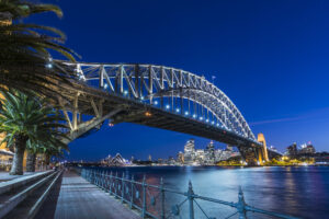 Sydney Harbour Bridge und beleuchtete Skyline bei Dämmerung